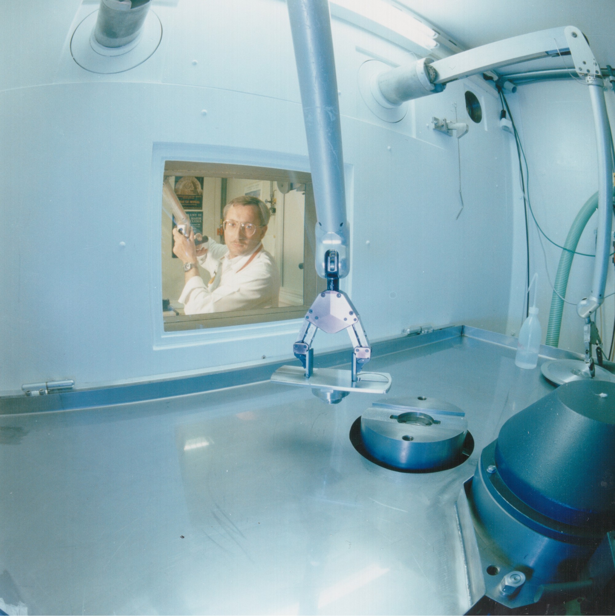 A person operating the gripper, view from the inside of the cell.