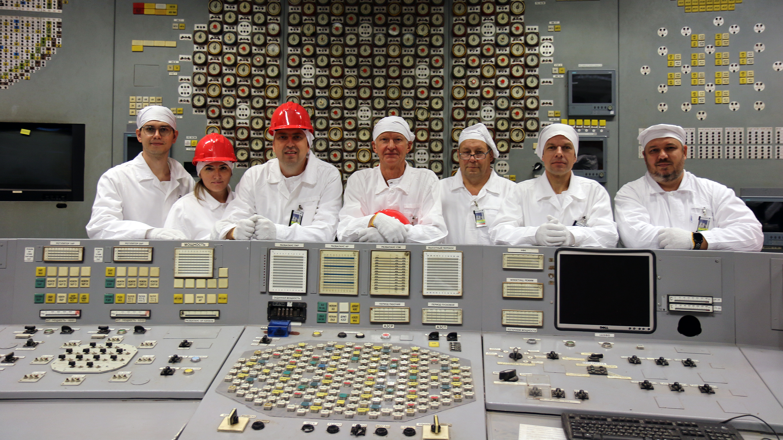 Group of seven people behind the desk of the control room at Ignalina NPP