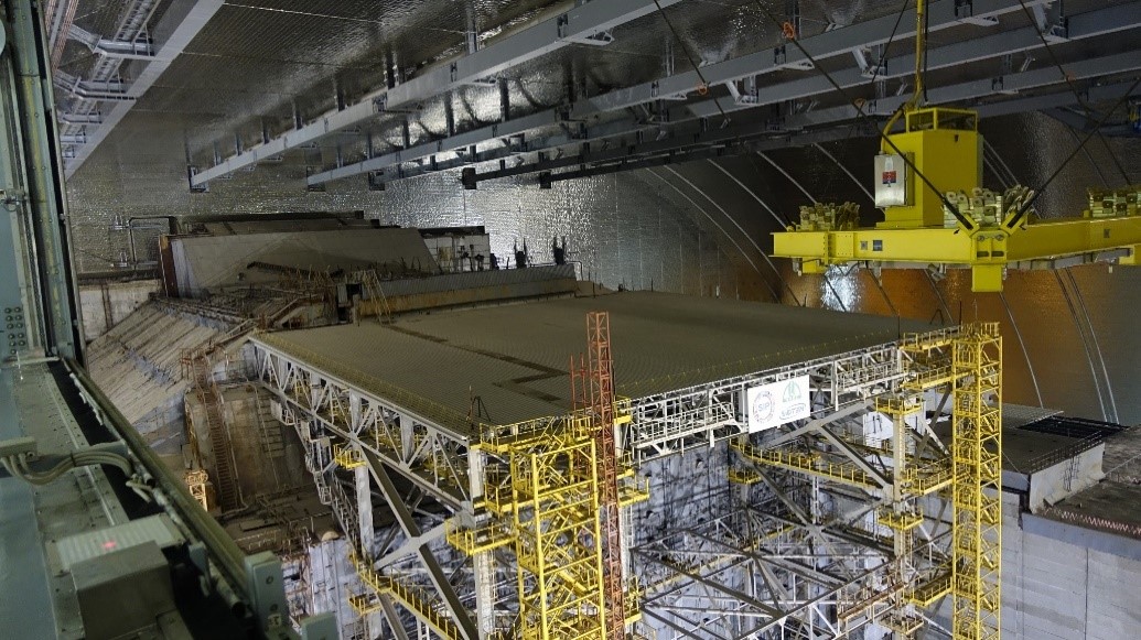 Figure 1: Interior of the New Safe Confinement, a stabilising structure in front, the old Sarcophagus behind (Source: ChNPP presentation May 2019).